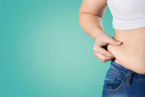 Image of woman pinching her love handles to show weight gain Tonbridge